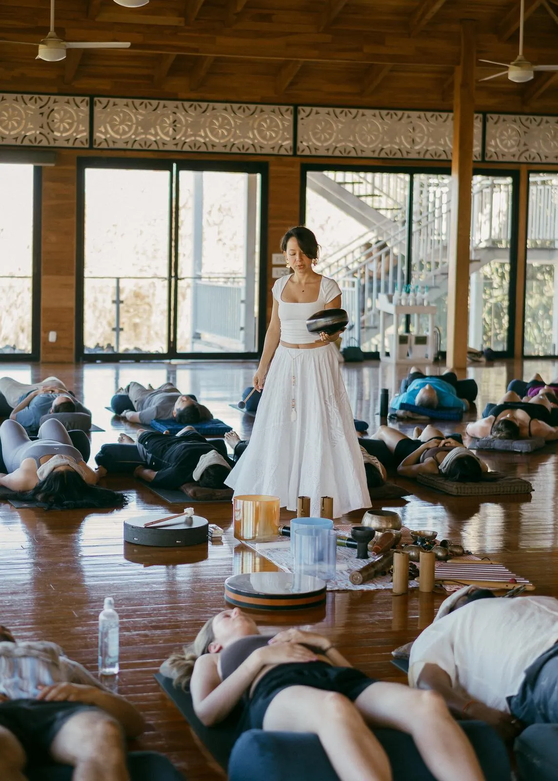 A sound healing session in an open-air studio in Nosara, guests lying on mats while the bride stands among them