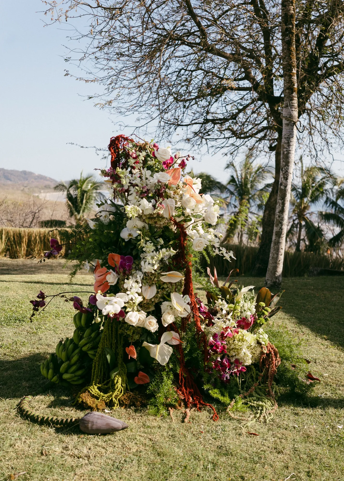 A lush tropical floral installation of anthurium and bougainvillea at a Nosara ceremony