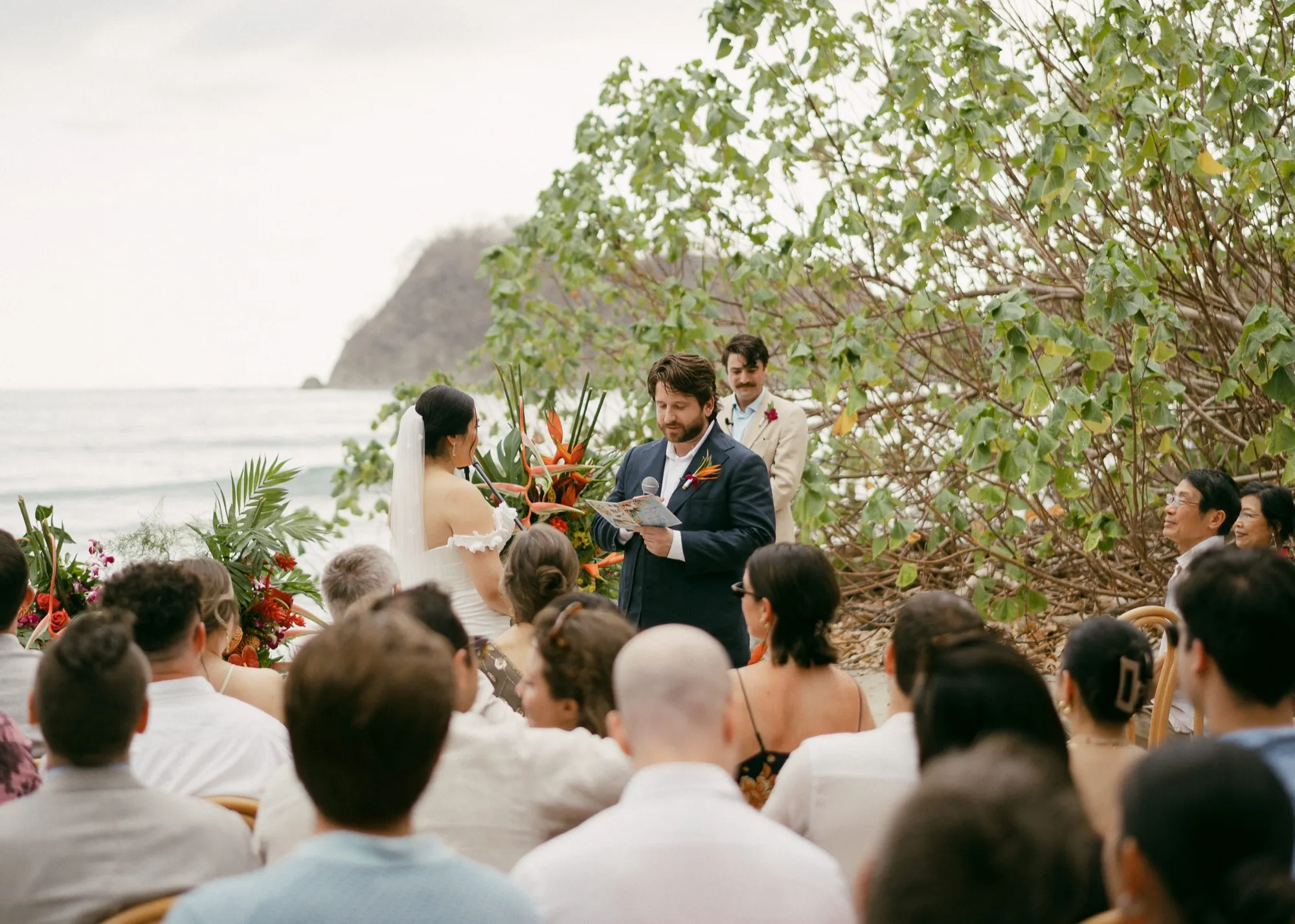 A beach ceremony at Nosara as the groom reads his vows before guests