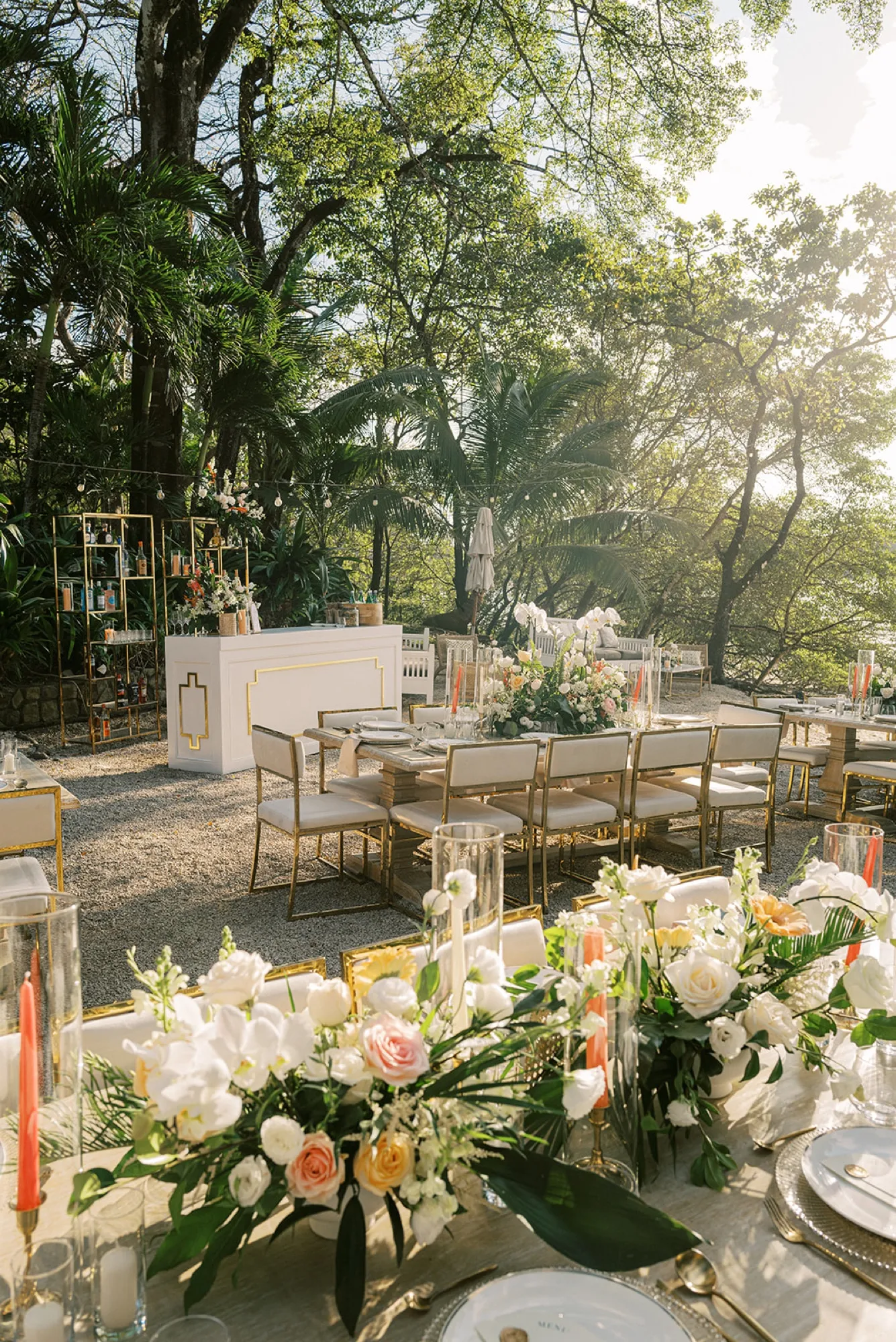 An elegant garden reception tablescape with blush and white florals at golden hour