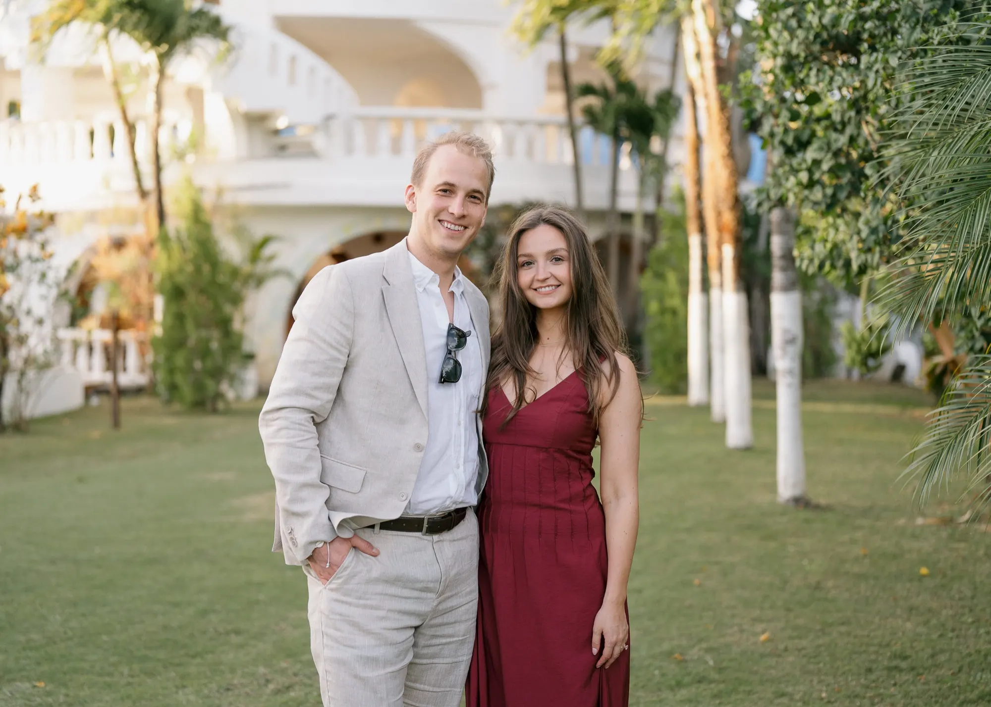 Two wedding guests in golden light on the lawn of a white villa in Nosara, Costa Rica
