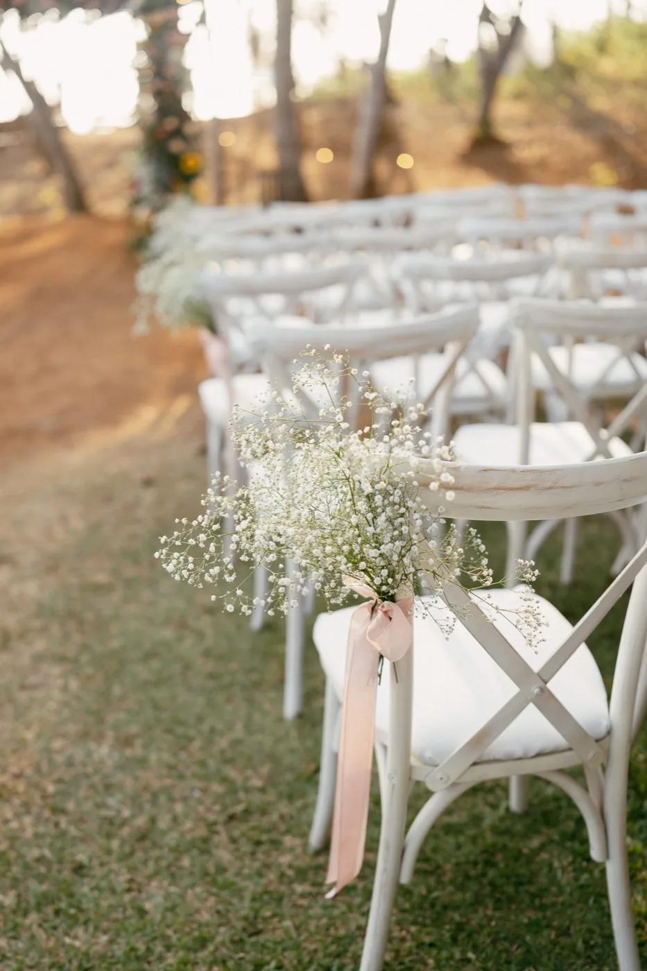 Baby's breath tied with a blush ribbon to a ceremony chair at a Nosara wedding