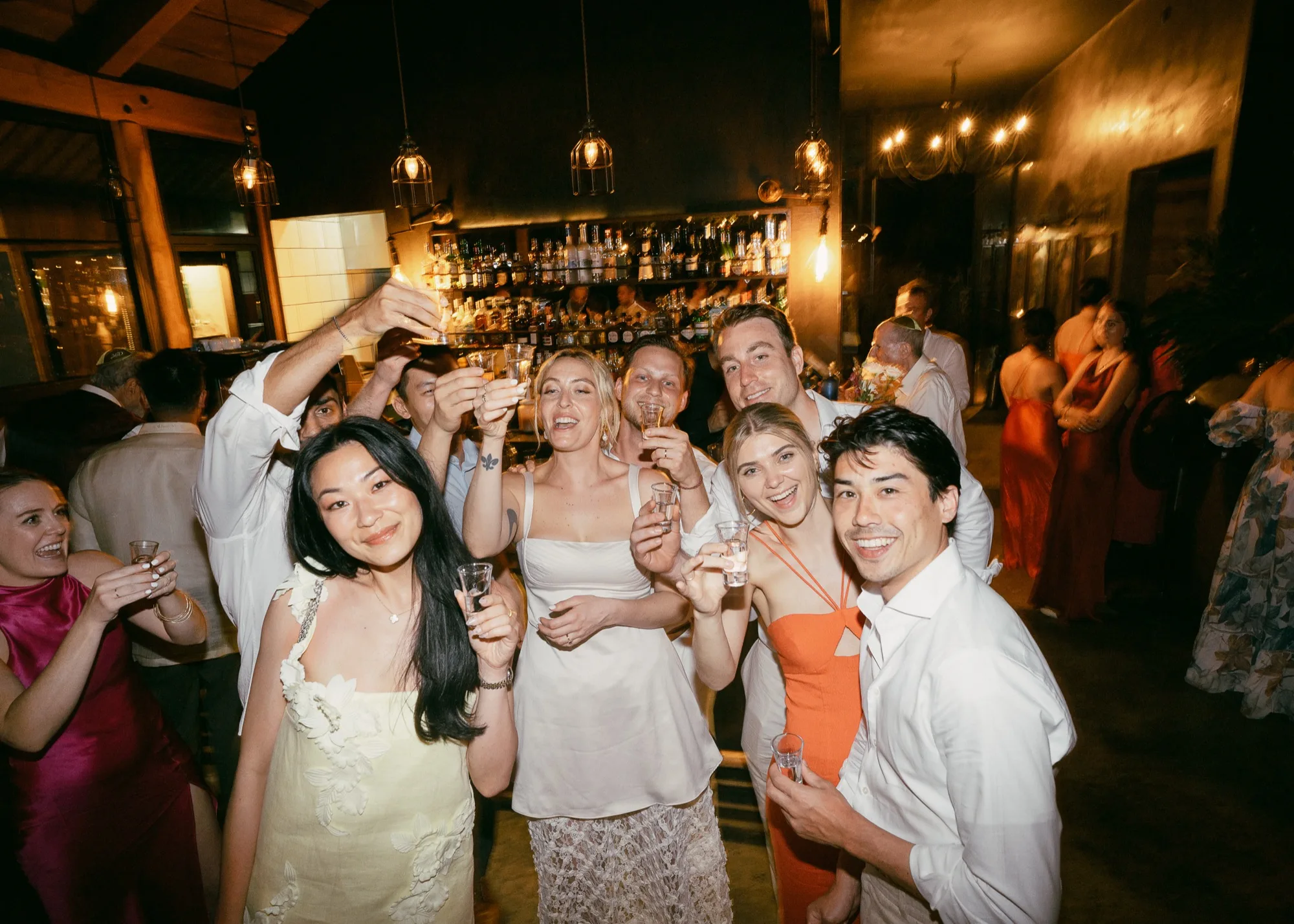 Guests raising a toast at a warm, candlelit Nosara wedding reception