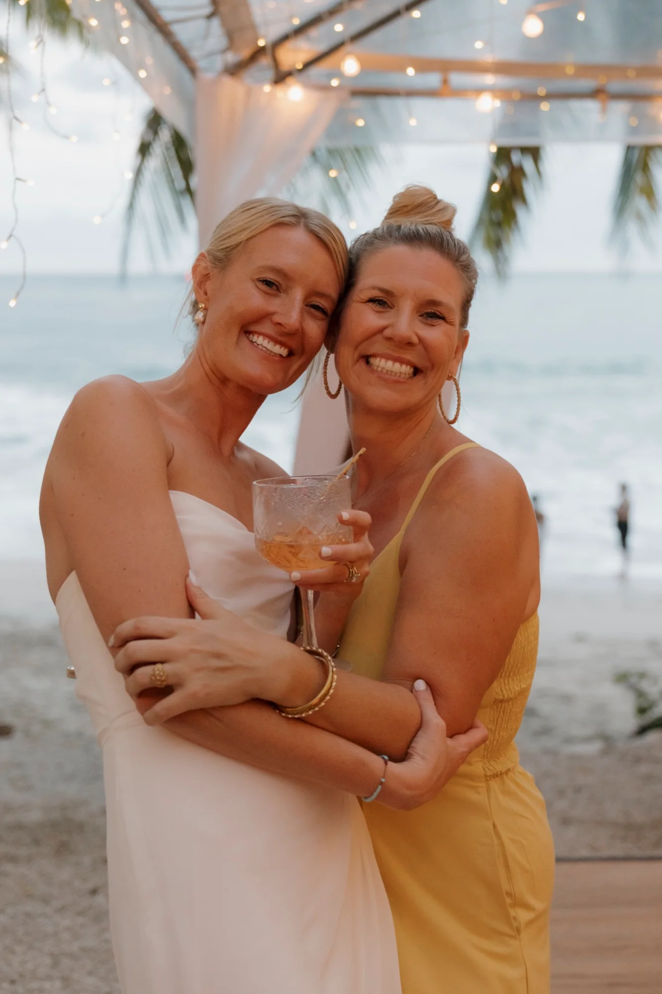 Stacie Brown embracing a bride at a beachside celebration in Nosara