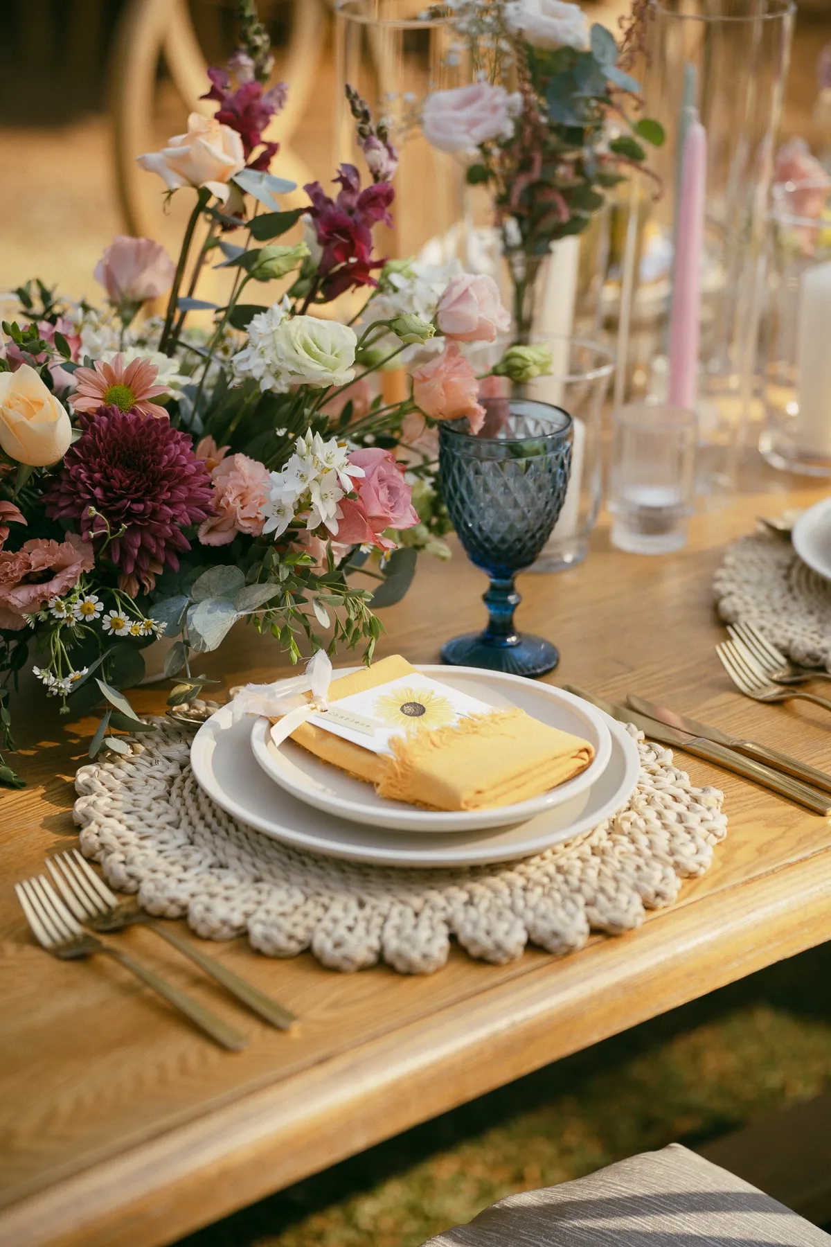 A wildflower centrepiece and place setting at a Nosara wedding table at golden hour