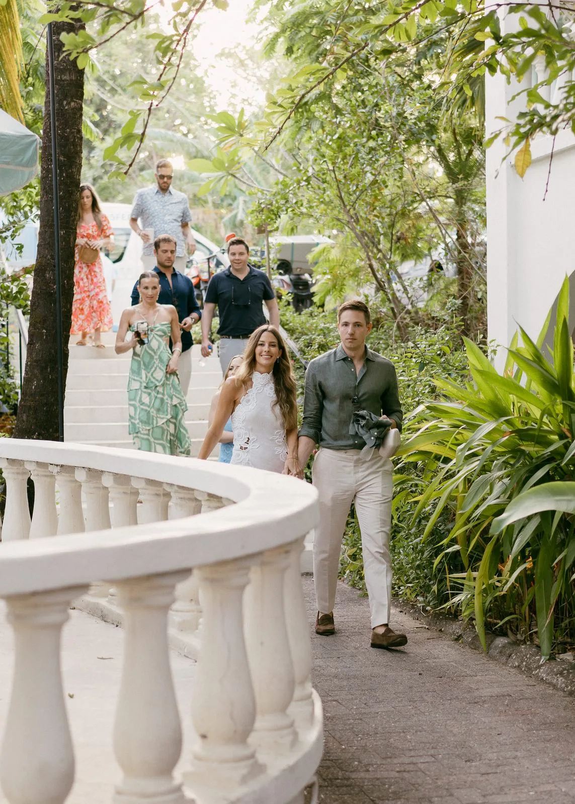 Guests arriving down a stone path between the palms for a welcome dinner in Nosara